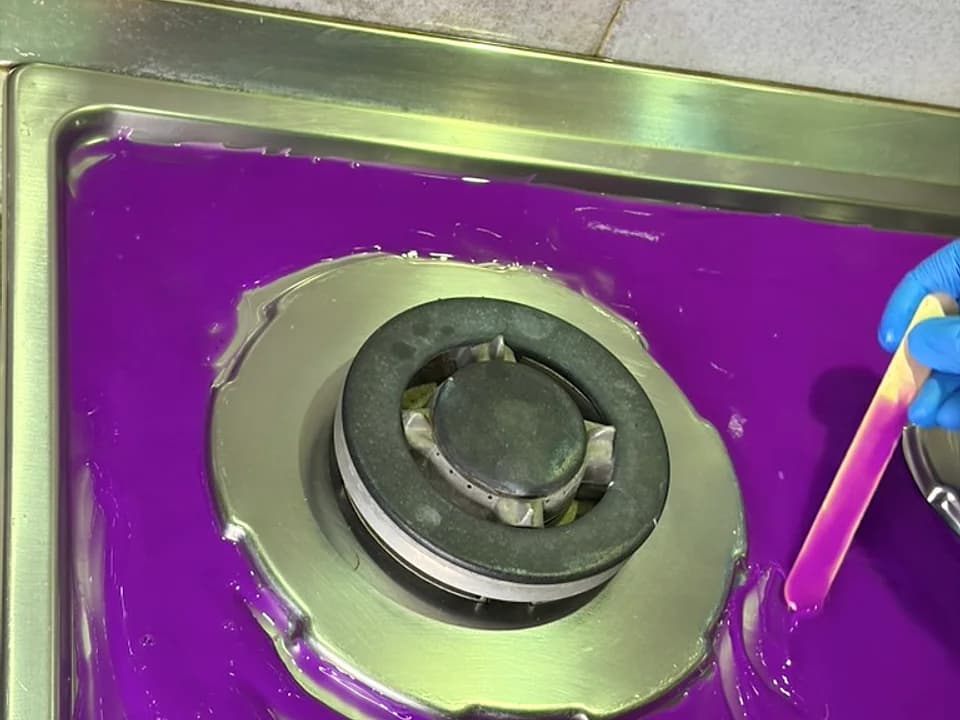 Purple Gummio being refined with a spatula on the hob
